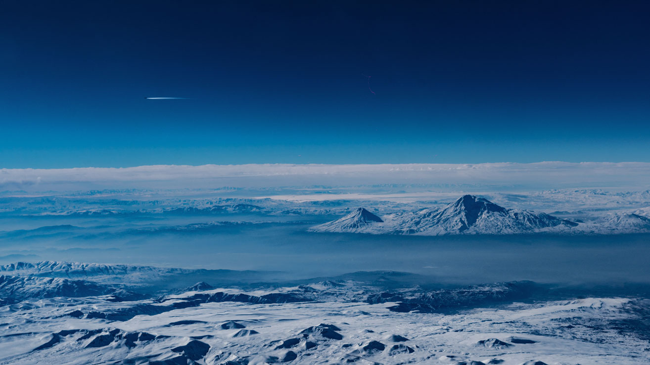 Looking out over cold snowy mountains from a plane