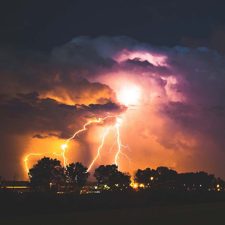 Image of lightning over trees at night