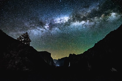 Mountains silhouetted against a starry night sky