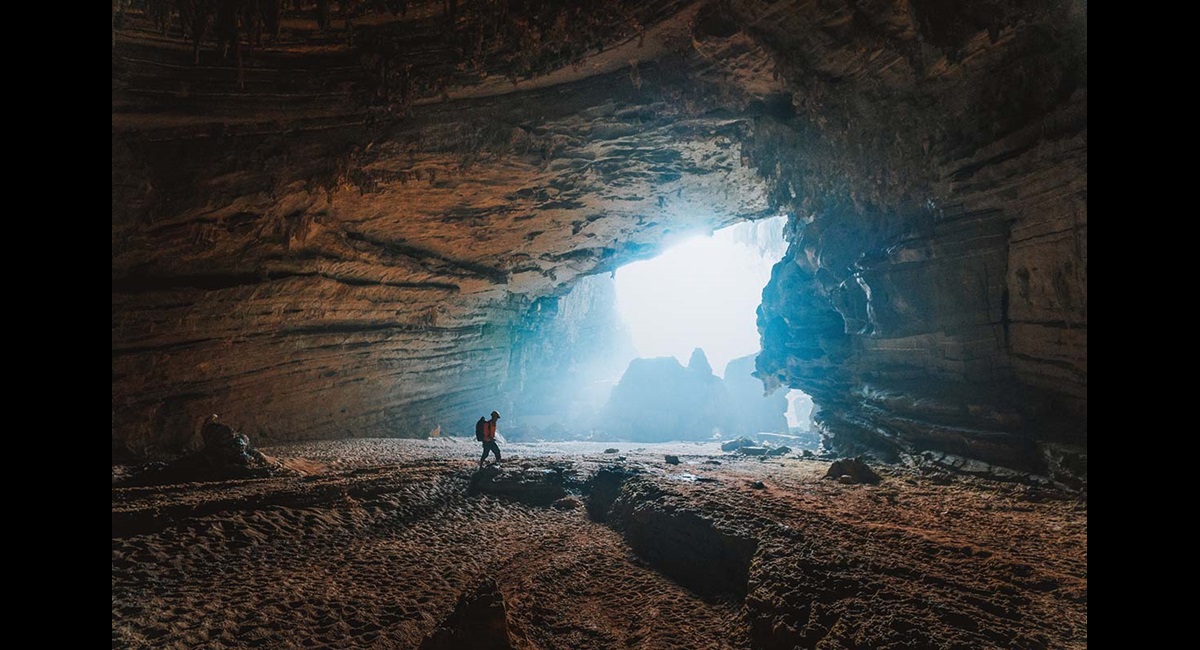 Person in cave with sunlight behind