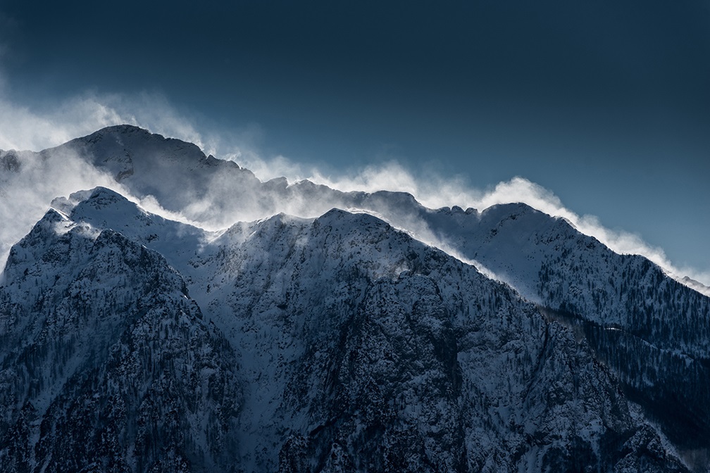 Snow blowing on top of mountain peaks