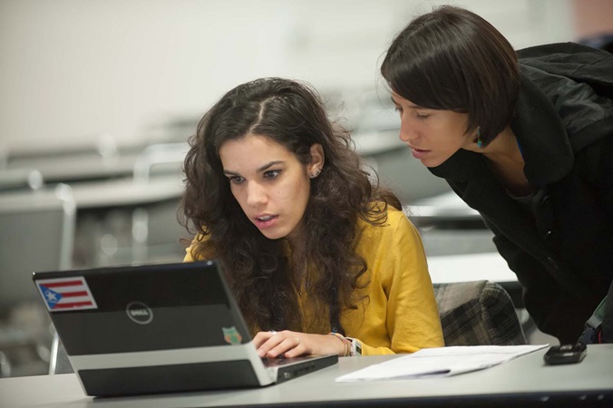 Teacher helping student on computer