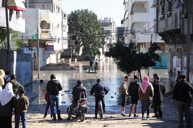 People looking out at flooded city streets.