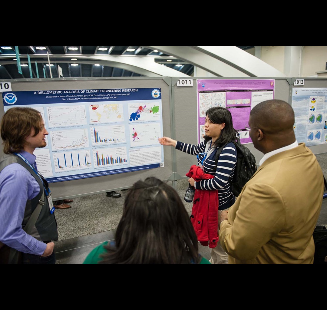 woman pointing and explaining poster to audience