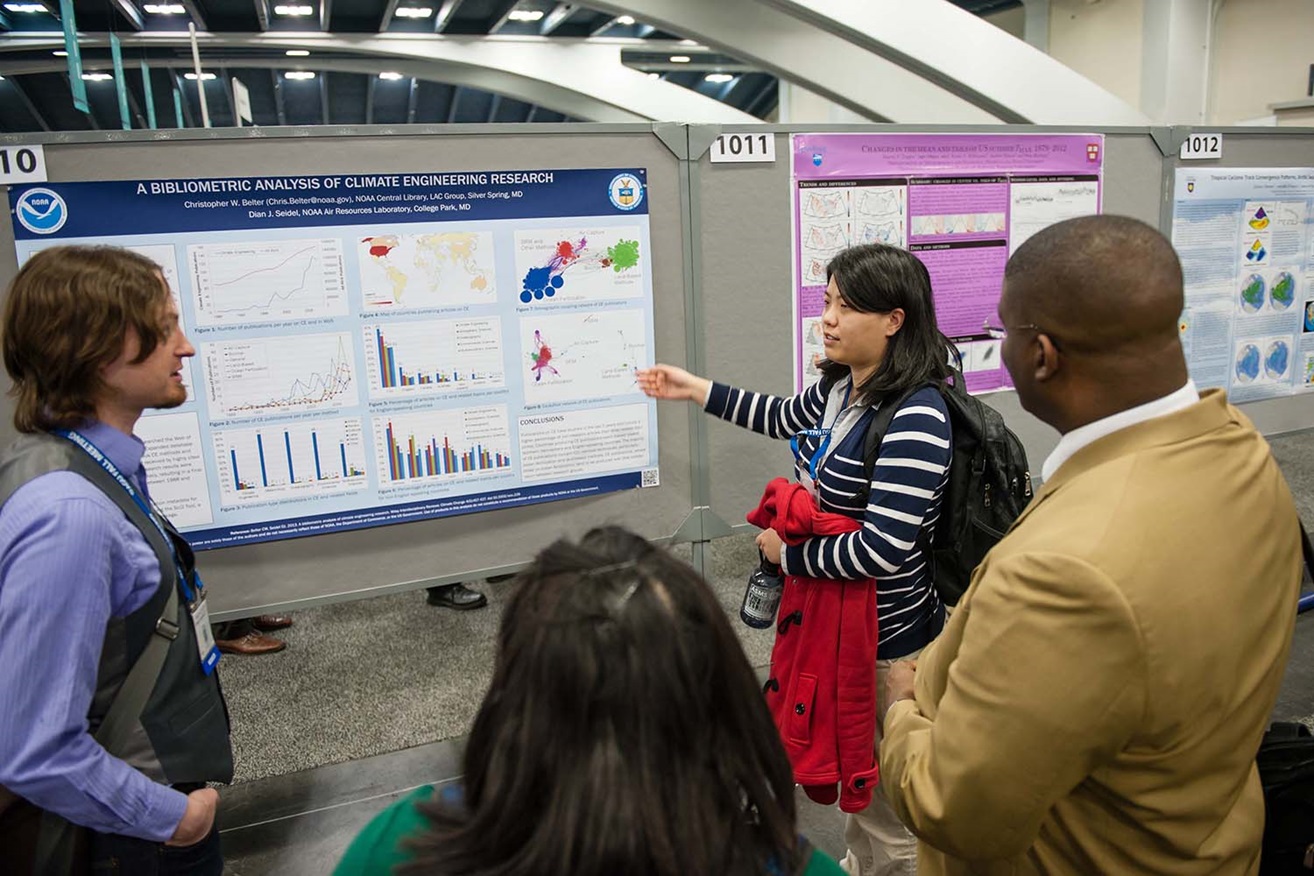 woman pointing and explaining poster to audience