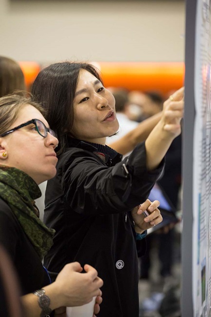 woman explaining to woman her poster
